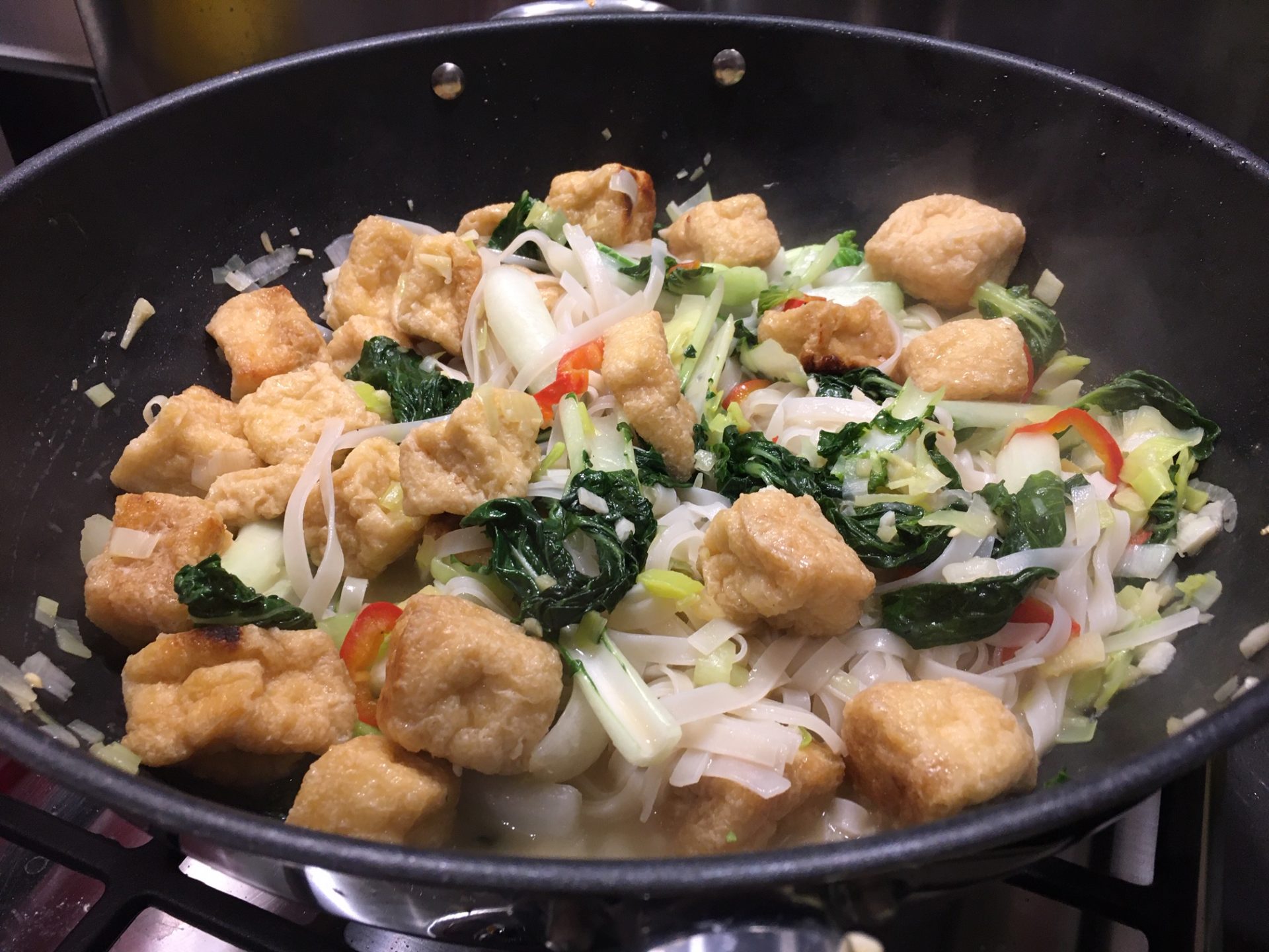 Cooking vegan sesame and ginger noodles with pak choi & teriyaki tofu